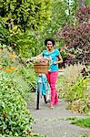 Woman riding retro bicycle with flower basket