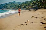 Woman walking on beach toward seashell