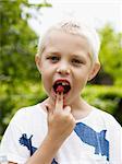 Portrait of boy eating raspberry