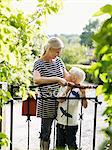 Mother and son standing by garden gate