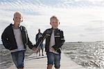 Two boys on jetty, father in background