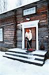 Woman removing snow from front steps