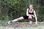 Young woman stretching in forest