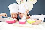 Little girls with chef's hat preparing dough, Munich, Bavaria, Germany