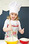 Little girl with chef's hat preparing dough, Munich, Bavaria, Germany