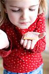 Little girl holding heart shaped cookie, Muich, Bavaria, Germany