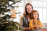 Mother and daughter decorating Christmas tree, Munich, Bavaria, Germany