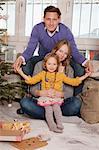 Parents with daughter alongside Christmas tree, Munich, Bavaria, Germany