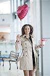 Woman runs to camera holding heart shaped balloon and gift