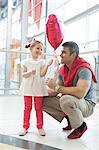 Father gives young daughter heart shaped balloon