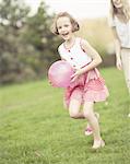 Mother and daughter playing with ball in the park