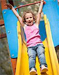 Close-up view of young girl on slide in playground