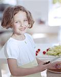 Young girl holding knife in kitchen