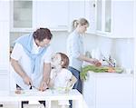 Father and Daughter looking at each other whilst preparing healthy meal in kitchen