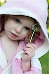 Little girl rubbing dandelion seedhead on face