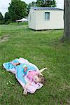 Little girl napping in sleeping bag on grass