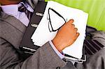 Close up of sleeping businessmans hand holding folder