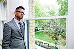 Portrait of Indian Businessman wearing glasses standing by the window