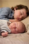 Baby and older brother sleeping side by side