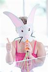 Girl in rabbit costume eating carrot