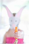 Girl in rabbit costume eating carrot