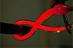 Close up of red hot glass being bent in glass factory