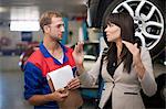 Car mechanic and customer discussing car repair