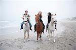 People riding horse on beach