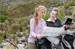 Two young female hikers looking at map