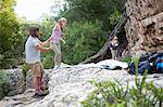 Young group of people setting up tent on rocks