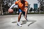 Young man playing basketball on court, close up