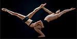 Mid adult dancers performing together in front of black background