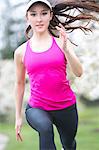 Teenage girl wearing pink sportswear running in park