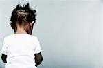 Portrait of baby boy wearing white vest, rear view