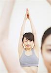 Woman with arms raised and hands together