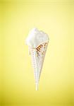 An ice cream cone with melting vanilla ice cream