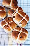 Several hot cross buns on a cooling rack
