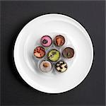 Assorted hand-made filled chocolates on a plate (view from above)