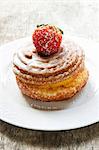 Yeast-raised pastry whirl with sugar glaze and a strawberry