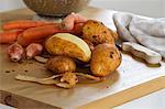 Carrots, shallots and potatoes; one potato partly peeled