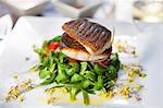 Crispy fried bass on a bed of lamb's lettuce with a lemon dressing