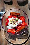 Strawberries with cream, pistachios and cinnamon sticks