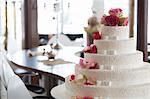 An elegant wedding cake decorated with white ribbons and pink roses