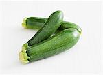 Three courgettes against a white background