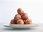 A stack of profiteroles on a plate against a white background