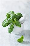 Fresh basil in a mortal with a pestle