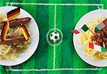 Sausages with cabbage (Germany) and spaghetti (Italy) with football-themed decoration