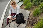 Young man studying text book in park