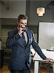 Young businessman drinking from cup in office