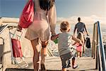 Young woman arriving at beach with son